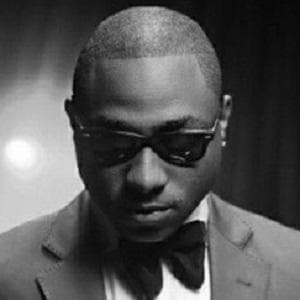 Davido holding a microphone while singing on stage at a concert